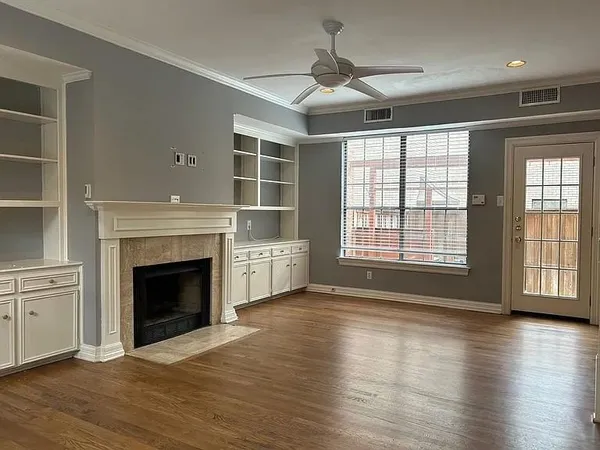 a view of an empty room with window and wooden floor