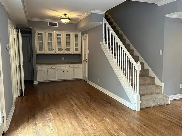 a view of a hallway with wooden floor and staircase