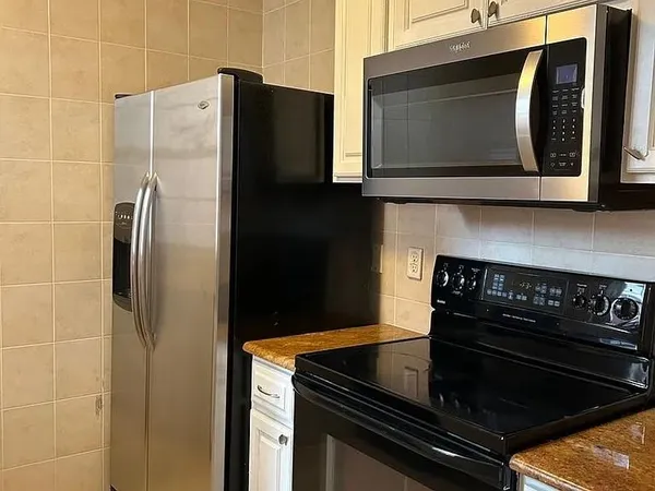 a kitchen with granite countertop a stove and a microwave