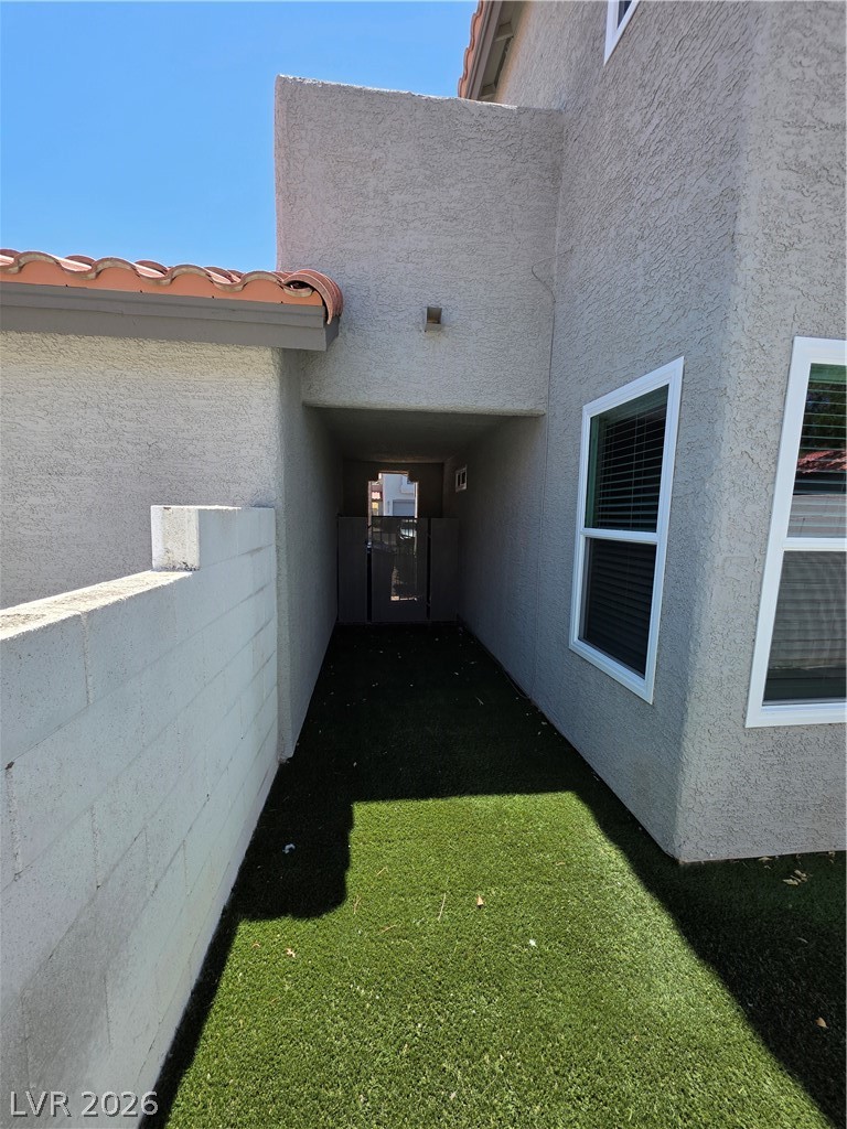 2275 Ramsgate Drive Henderson, NV 89074 - Photo 14 of 84 A stucco exterior with red tile roofing borders a meticulously maintained artificial turf area.