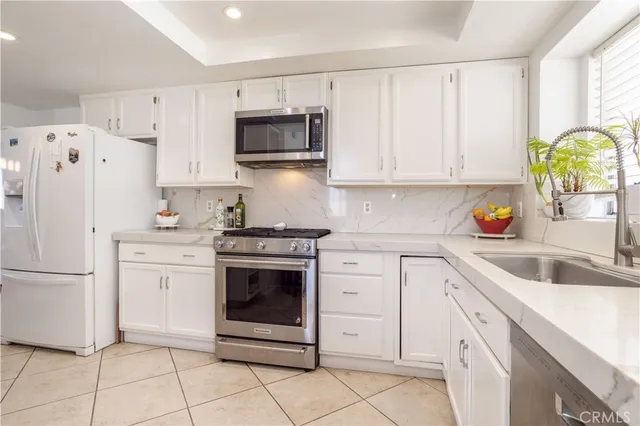 a kitchen with white cabinets and white appliances