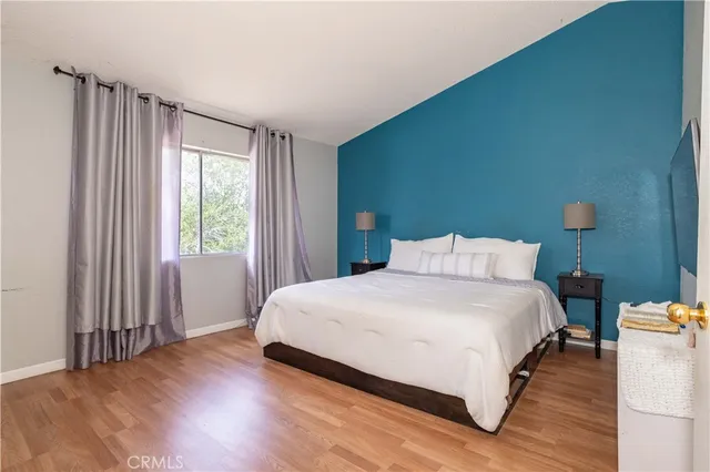 a bedroom with a bed lamp and a large window