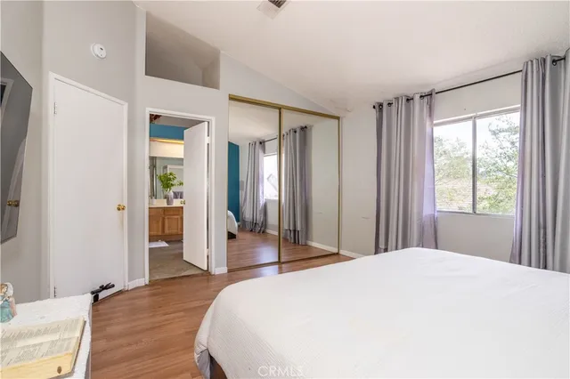 a spacious bedroom with a large bed and wooden floor