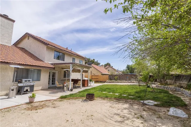 a backyard of a house with table and chairs