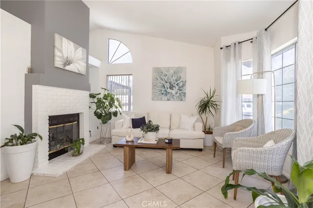 a living room with furniture a fireplace and a potted plant