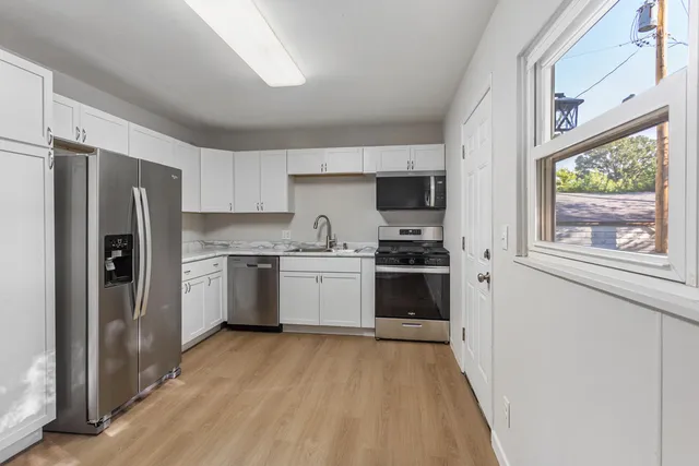 a kitchen with a refrigerator a sink and a stove top oven