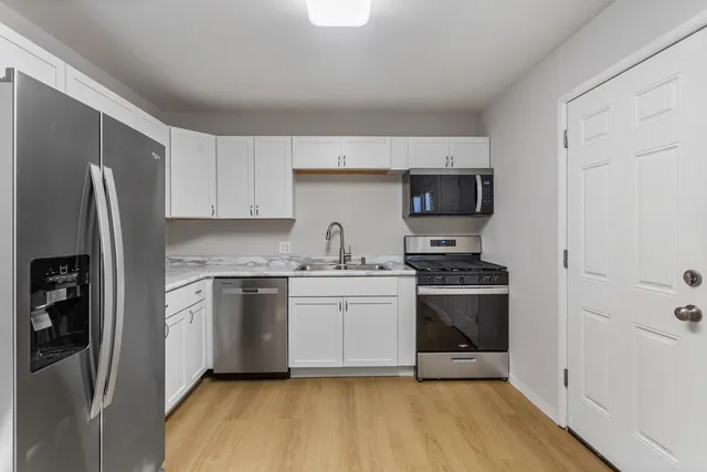 a kitchen with stainless steel appliances a stove a sink and a refrigerator