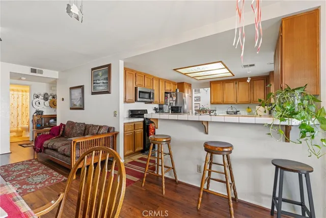 a kitchen with stainless steel appliances kitchen island granite countertop a table and chairs in it