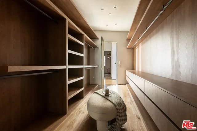 a view of walk in closet with wooden floor