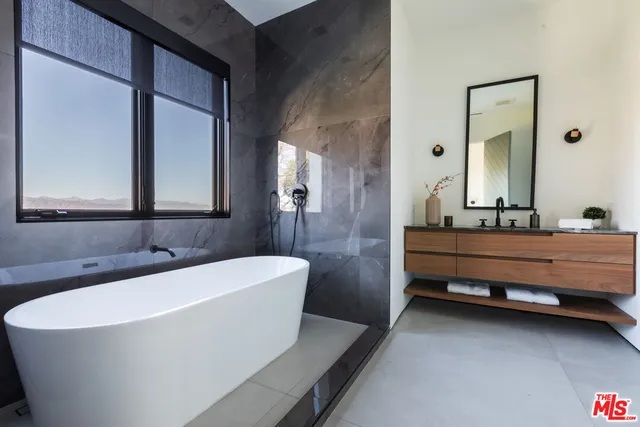 a room with a table chairs workspace and a mirror