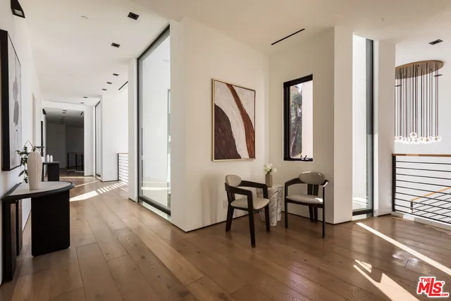 a view of a hallway with wooden floor and furniture