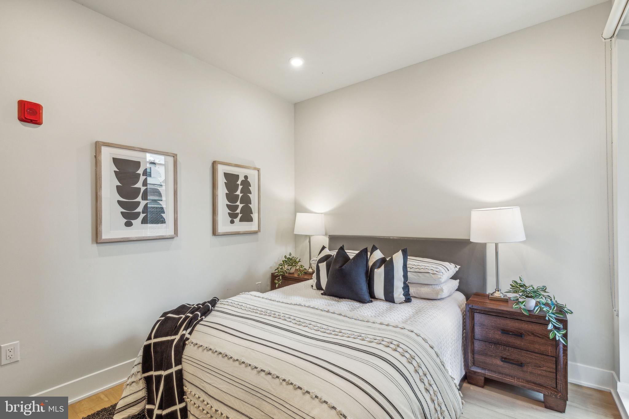 6910 Ridge Avenue, Unit 116 Philadelphia, PA 19128 - Photo 15 of 23 a bedroom with a bed and a lamp