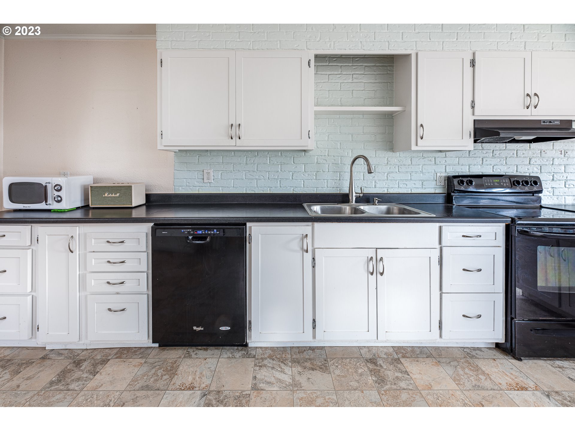 1013 M Street Springfield, OR 97477 - Photo 10 of 35 a kitchen with granite countertop a sink cabinets and stainless steel appliances