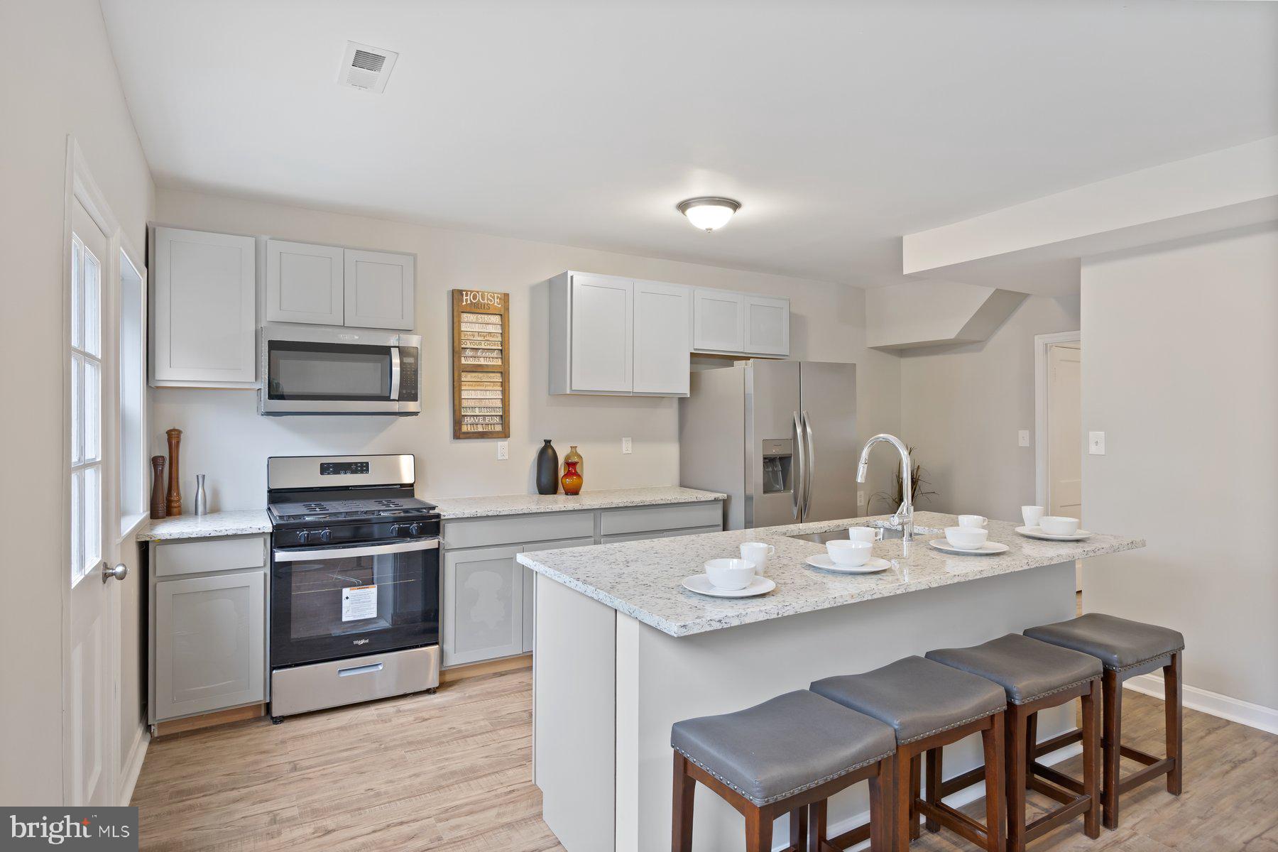 1526 Sheffield Road Baltimore, MD 21218 - Photo 3 of 20 a kitchen with a stove a sink and a refrigerator