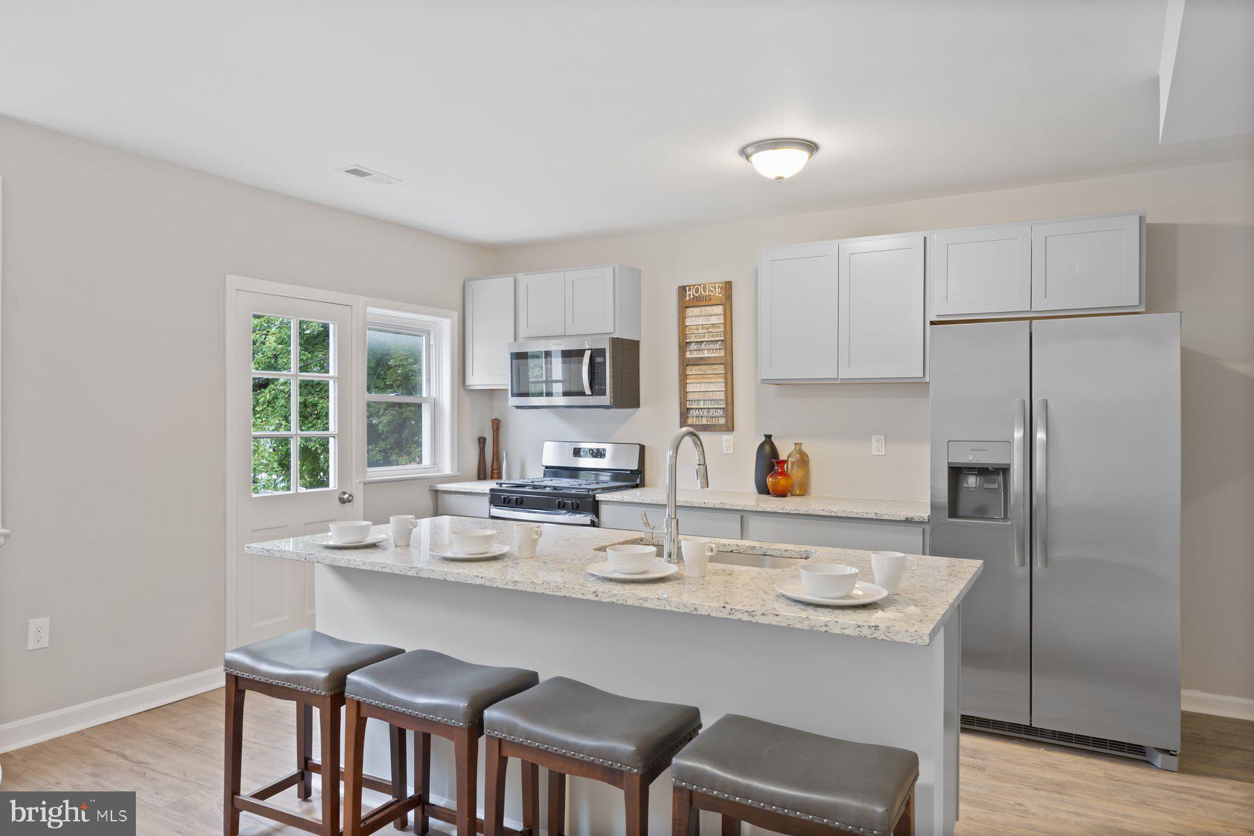 1526 Sheffield Road Baltimore, MD 21218 - Photo 4 of 20 a kitchen with a dining table chairs and refrigerator