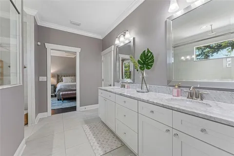 a bedroom with a bed chandelier and pink walls