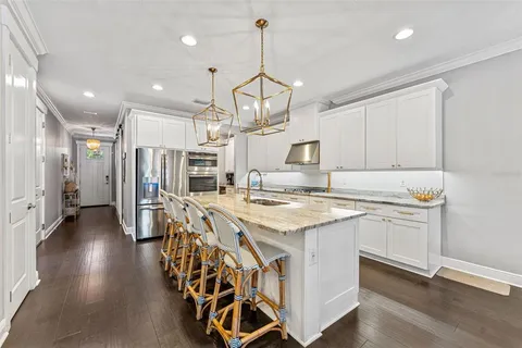 a large kitchen with kitchen island a large counter space a sink stainless steel appliances and cabinets