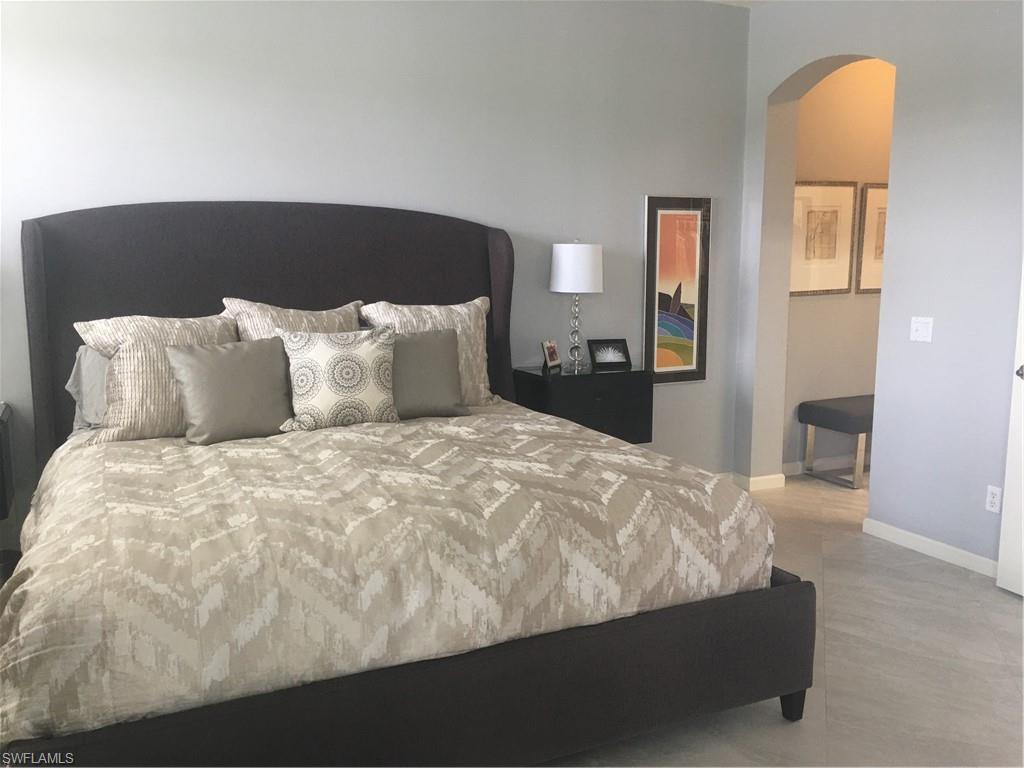 23091 Rosedale Drive, Unit 101 Estero, FL 34135 - Photo 6 of 12 a large bed sitting in a bedroom next to a window