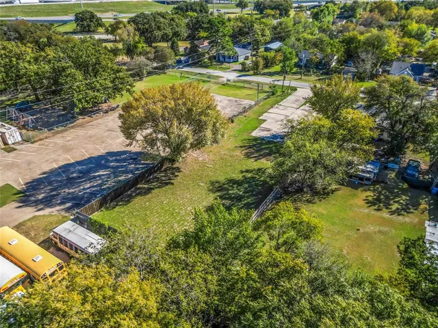 a view of a swimming pool with a yard and large trees