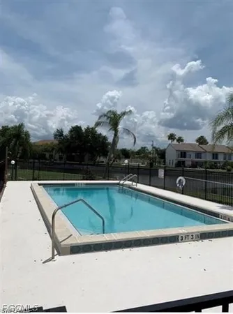 a view of swimming pool with outdoor seating and buildings in the background