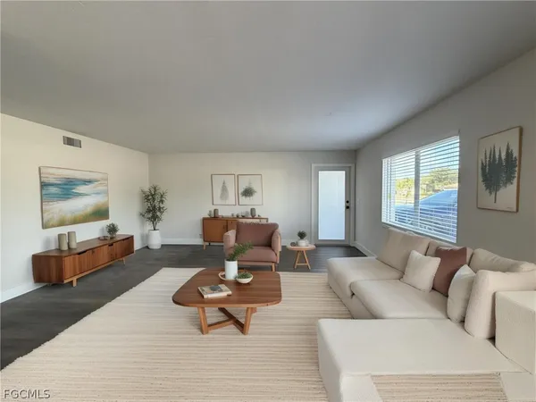 a living room with furniture and wooden floor