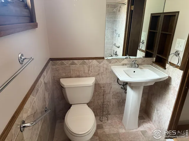 a bathroom with a toilet sink and mirror
