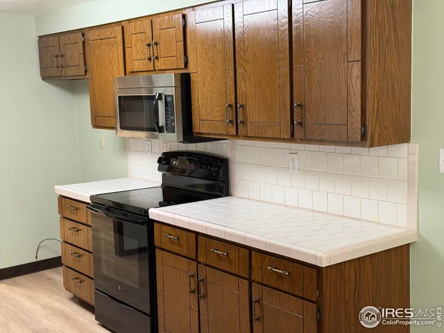 a kitchen with stainless steel appliances granite countertop a sink stove and microwave