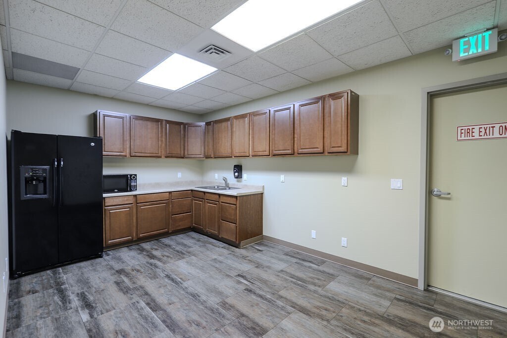 151 South Worthen Street, Unit 1 Wenatchee, WA 98801 - Photo 13 of 27 a kitchen with granite countertop a refrigerator and wooden cabinets