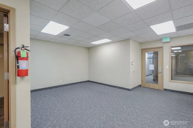 an empty room with a bathroom and windows