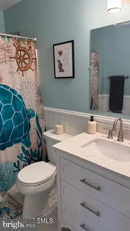 a bathroom with a granite countertop toilet sink and mirror