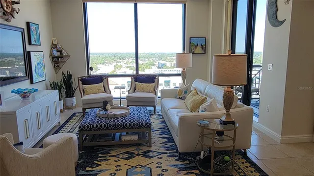 a living room with furniture and a floor to ceiling window