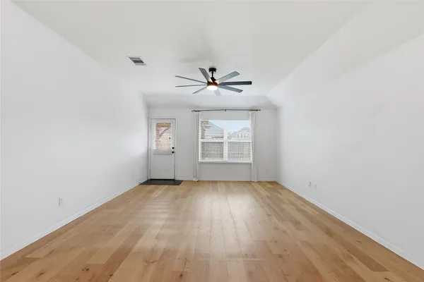 a view of a livingroom with a kitchen space with wooden floor