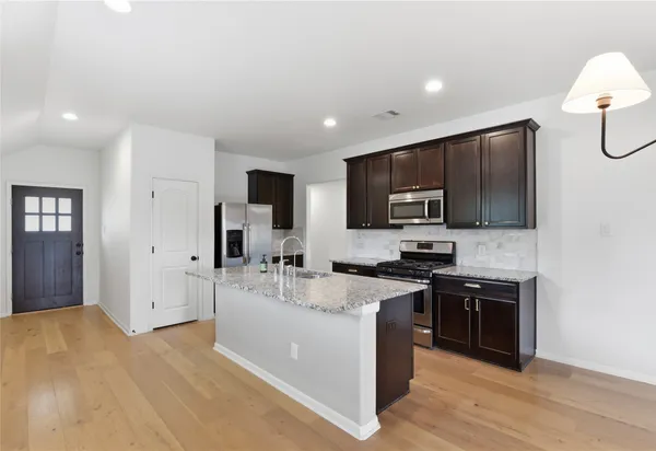 a kitchen with stainless steel appliances granite countertop a sink stove and refrigerator