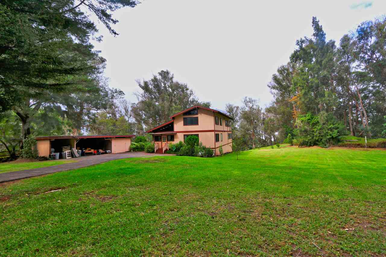 a front view of a house with a yard and trees