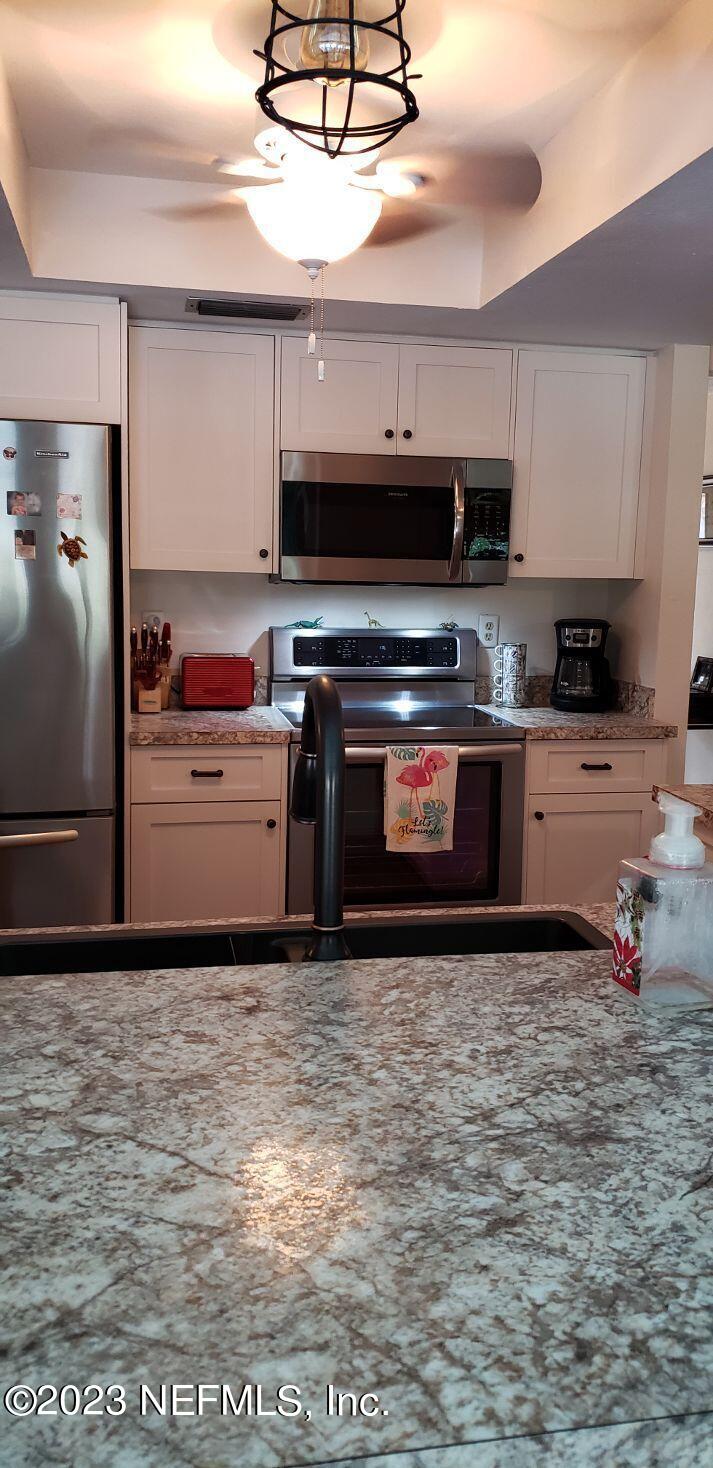 11451 Trip Avenue Weeki Wachee, FL 34614 - Photo 35 of 46 a kitchen with stainless steel appliances granite countertop a stove a sink and a microwave