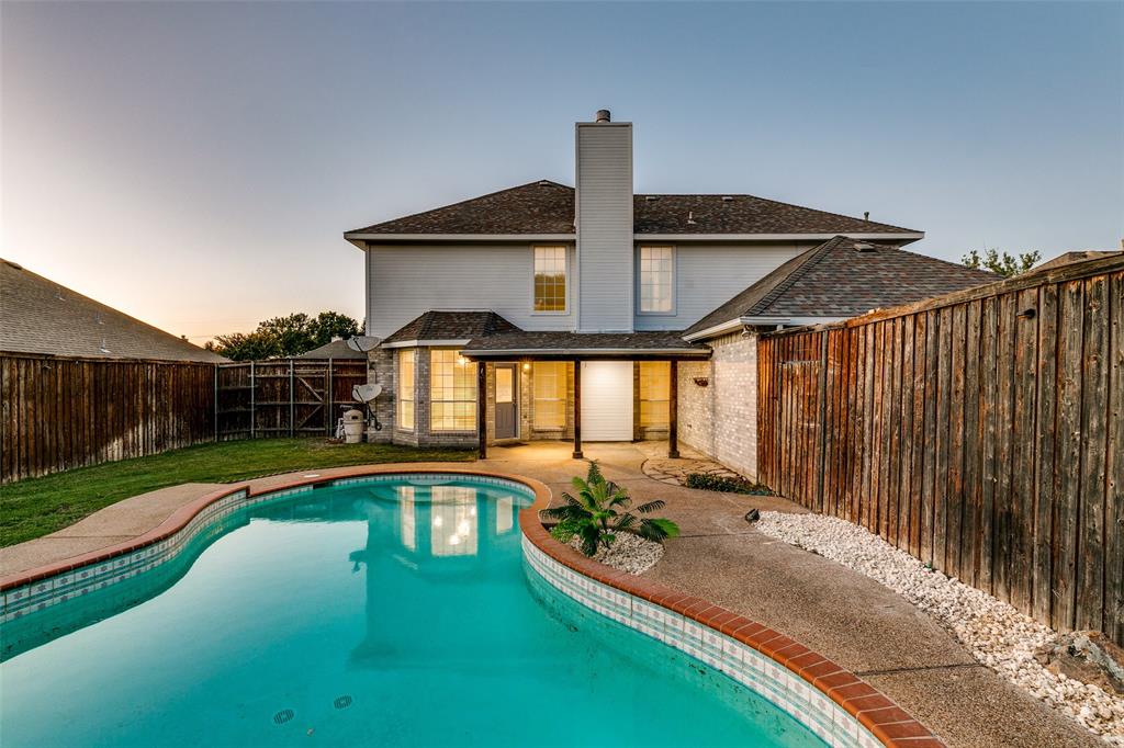 4532 Crown Ridge Drive Plano, TX 75024 - Photo 25 of 25 Rear exterior featuring an inground swimming pool with a concrete surround, wood privacy fencing, and a covered patio with architectural columns