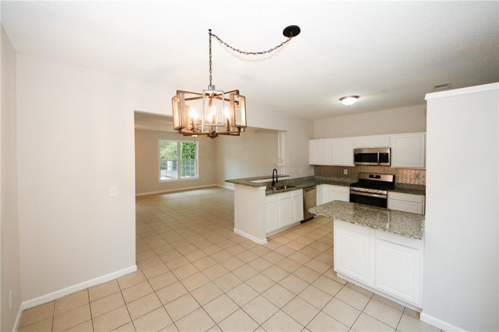 4645 Valais Court, Unit 90 Alpharetta, GA 30022 - Photo 12 of 24 a kitchen with stainless steel appliances granite countertop a sink and a stove