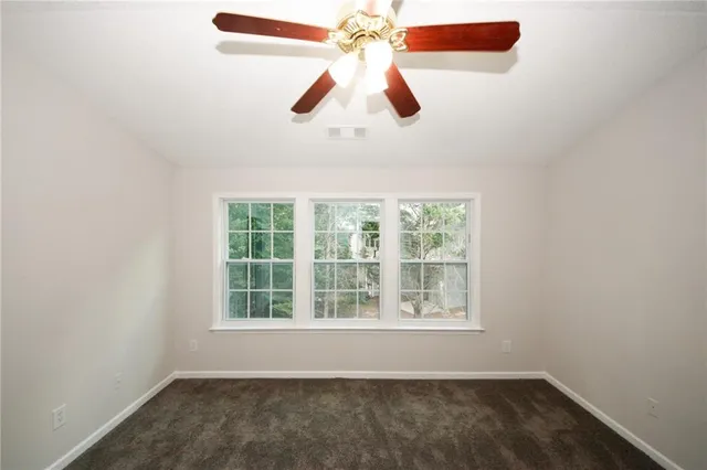 an empty room with a window and a ceiling fan