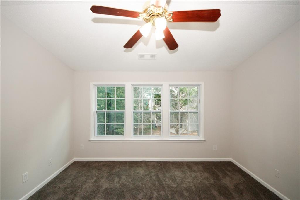 4645 Valais Court, Unit 90 Alpharetta, GA 30022 - Photo 17 of 24 an empty room with a window and a ceiling fan