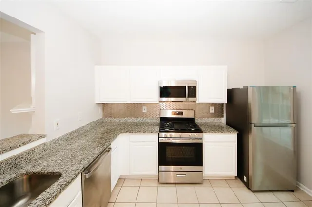 a kitchen with cabinets and white stainless steel appliances