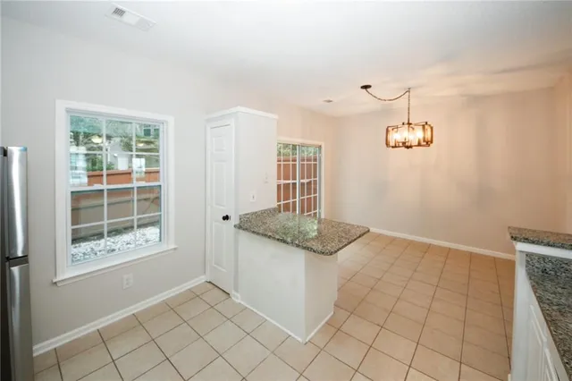 a kitchen with granite countertop white cabinets and window