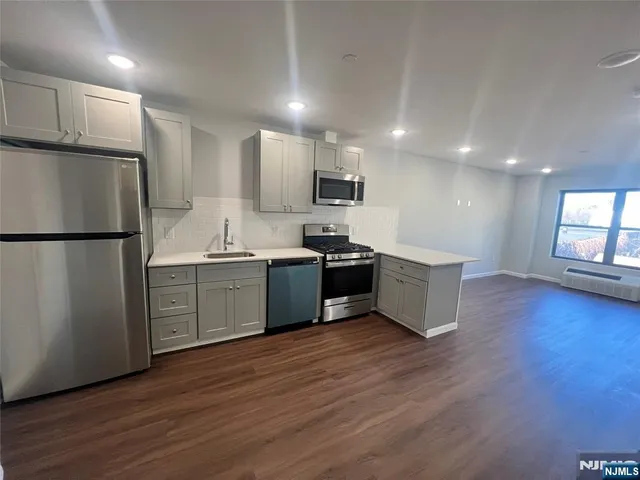 a kitchen with stainless steel appliances a refrigerator sink and microwave