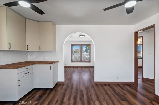 a view of a hallway with wooden floor and cabinets