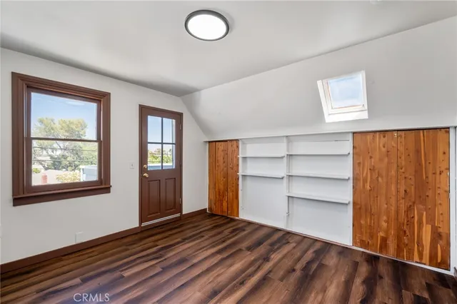 a view of empty room with wooden floor and window