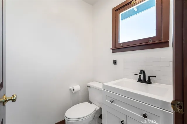 a bathroom with a toilet a sink and mirror