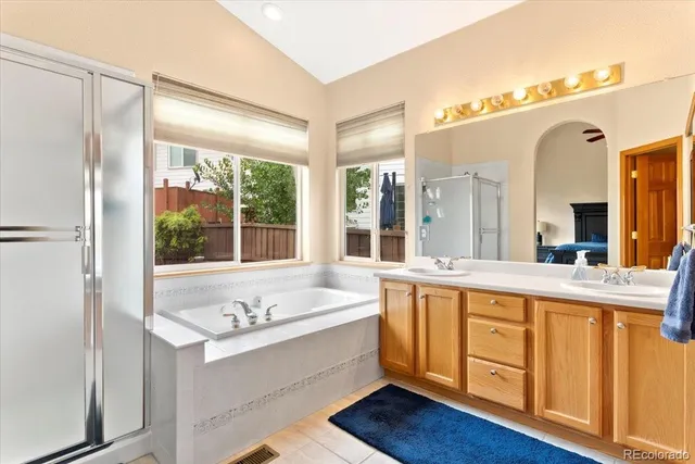 a spacious bathroom with a tub sink shower and mirror