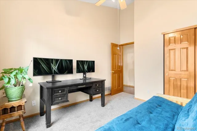 a view of a workspace with furniture and a window