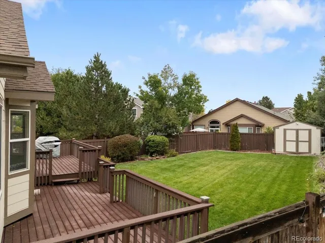 a view of a house with wooden deck and furniture