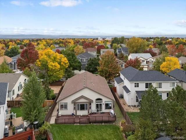 an aerial view of residential houses with outdoor space and trees
