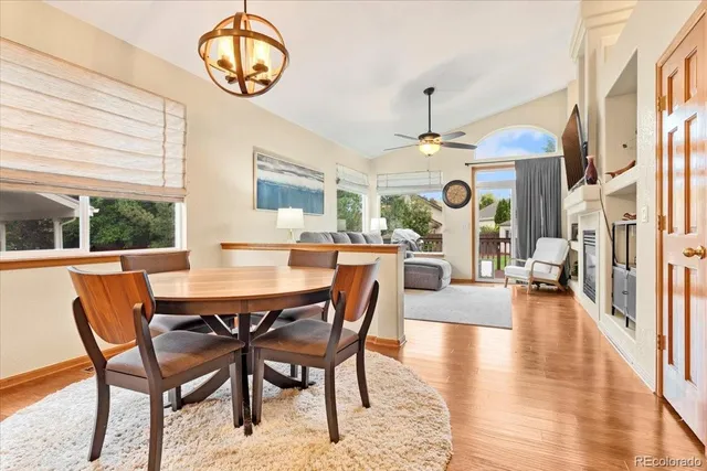a dining room with wooden floor a chandelier a wooden table and chairs